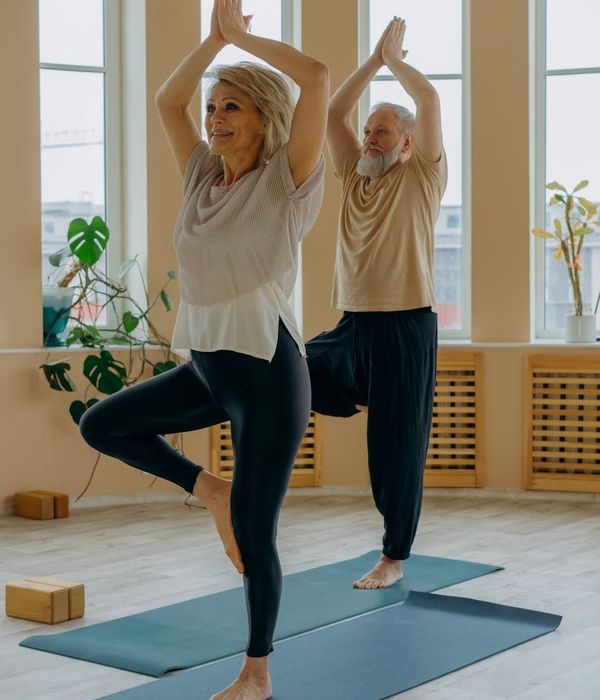A mature woman smiling peacefully after a yoga practice.